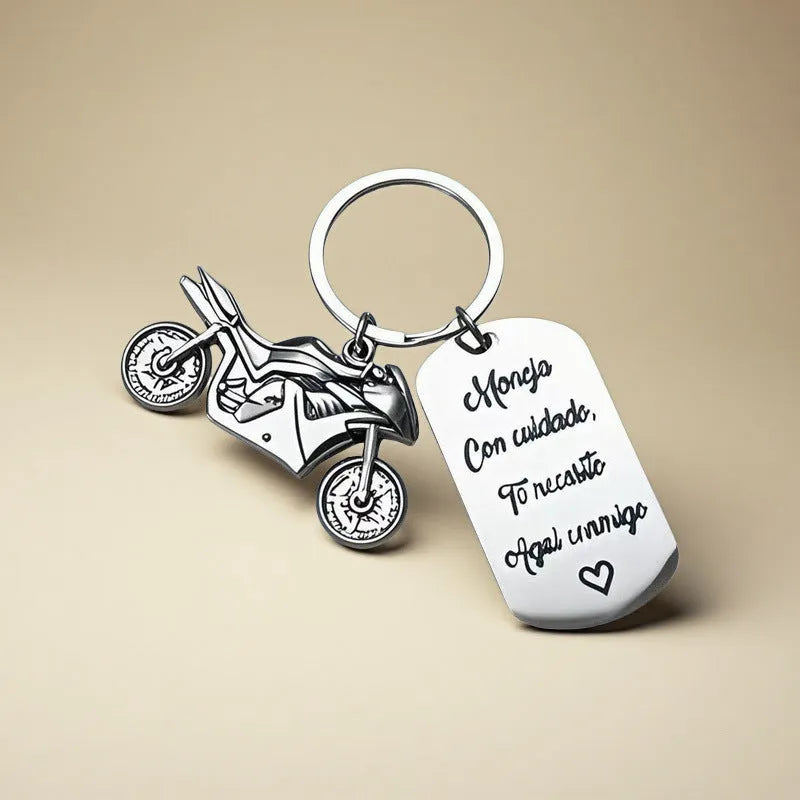 Polished stainless steel motorcycle key ring with inspirational charm on a flannel bag.