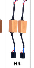 Black alloy LED Canbus decoder for H4 H7 H11 car headlight bulbs on a white background.