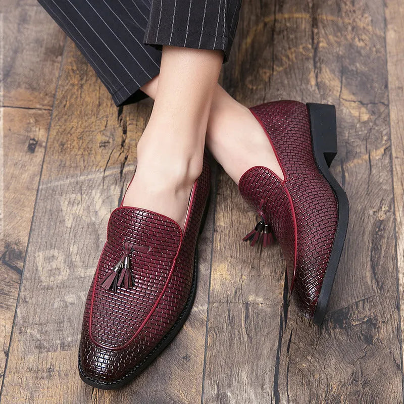 Men's black pointed toe slip on shoes with a gold tassel detail on the upper.