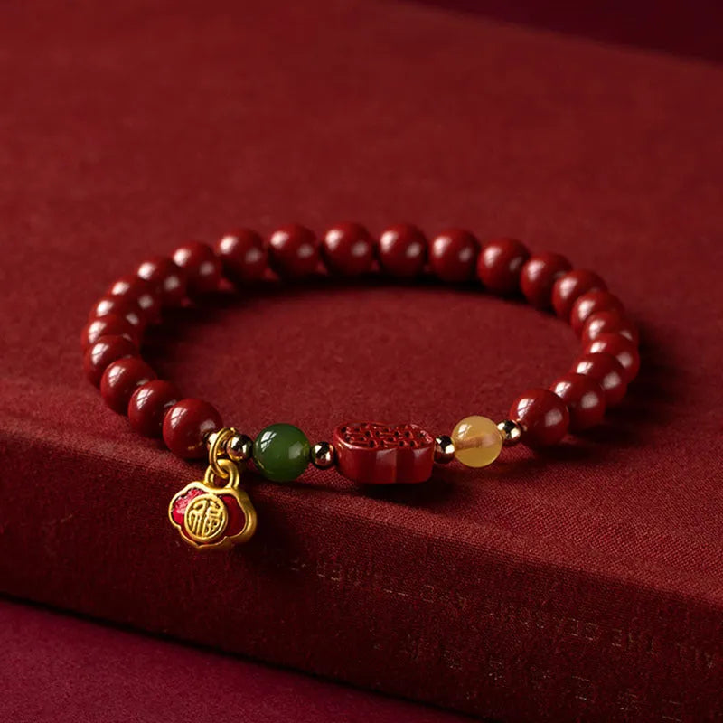 Chinese cinnabar bracelet with emperor sandstone beads and a carved fu character symbol.