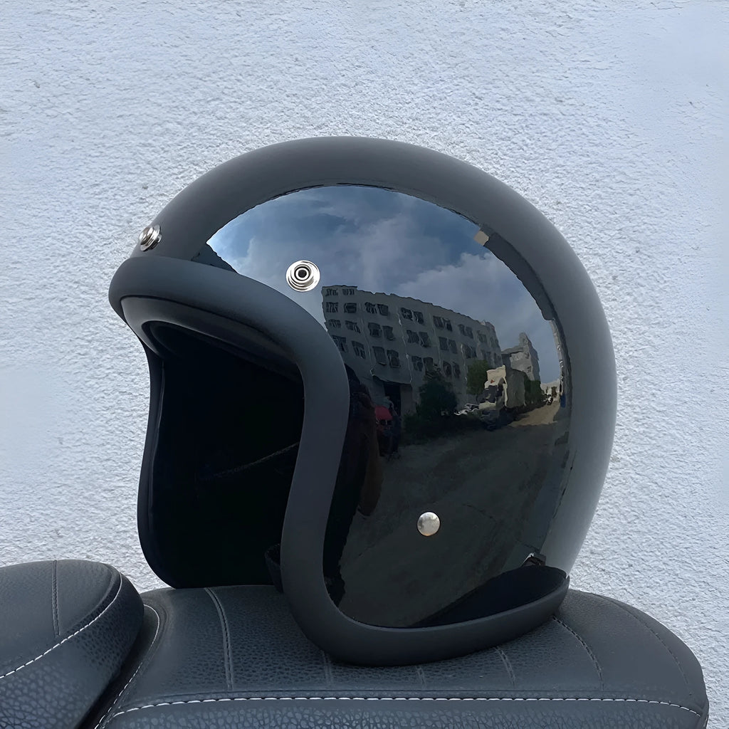 A cement grey retro-style motorcycle half helmet with a floral pattern on the side, showing its open-face design.