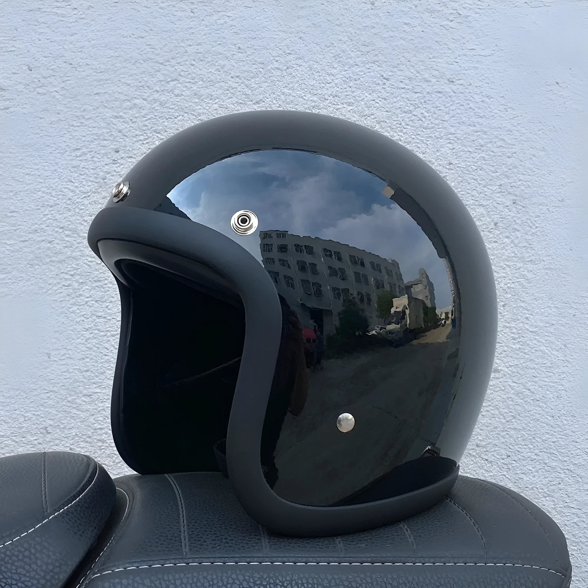 A cement grey retro-style motorcycle half helmet with a floral pattern on the side, showing its open-face design.