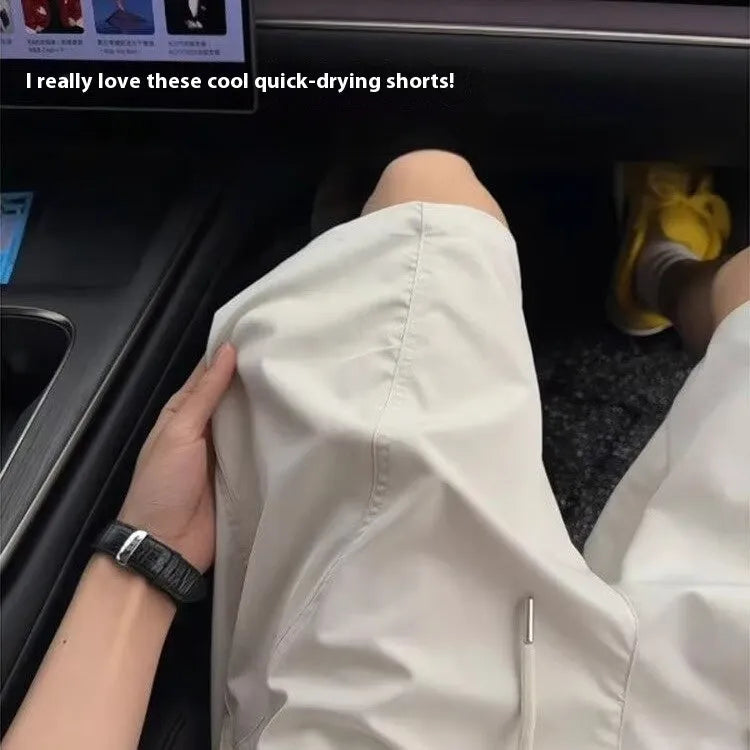 Men's quick-drying sports shorts in polyester with elastic waistband, shown in creamy-white colour