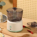 White and light green mini electric meat grinder with transparent cup and stainless steel blades