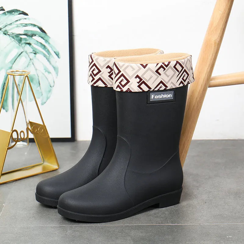 Women's mid-calf PVC rain boot in black with a low heel on a white background.