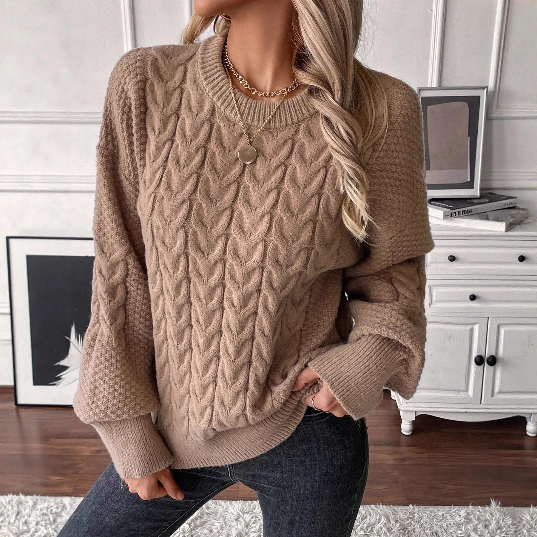 Women's loose beige casual sweater with round neck and twist detail on a hanger.