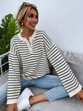 Black striped women's loose long-sleeve top with drop shoulders on a hanger.