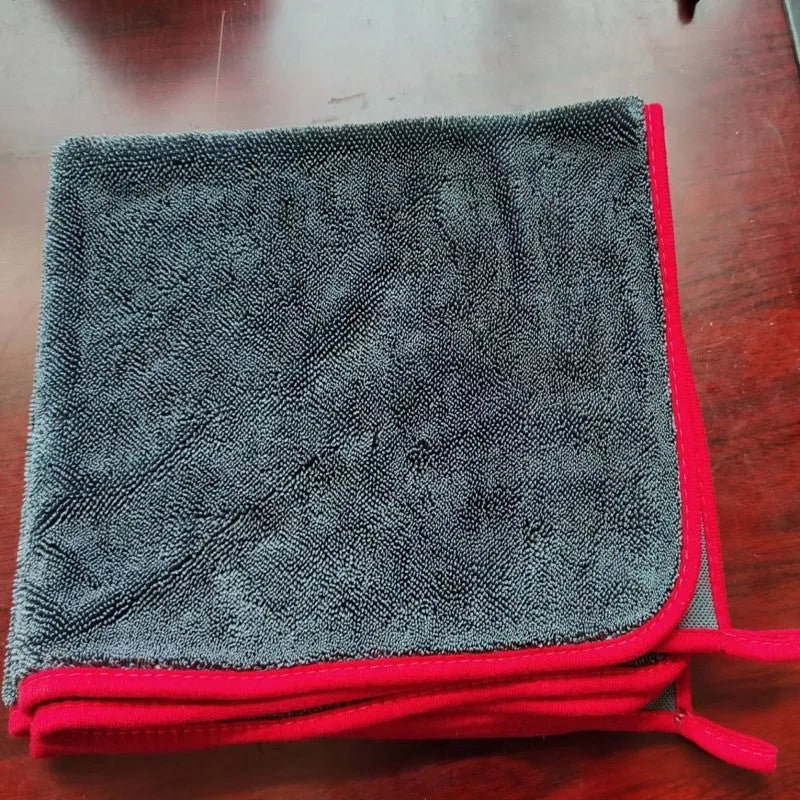Grey car cleaning towel with red edge trim showing braided texture, laid flat to show dimensions