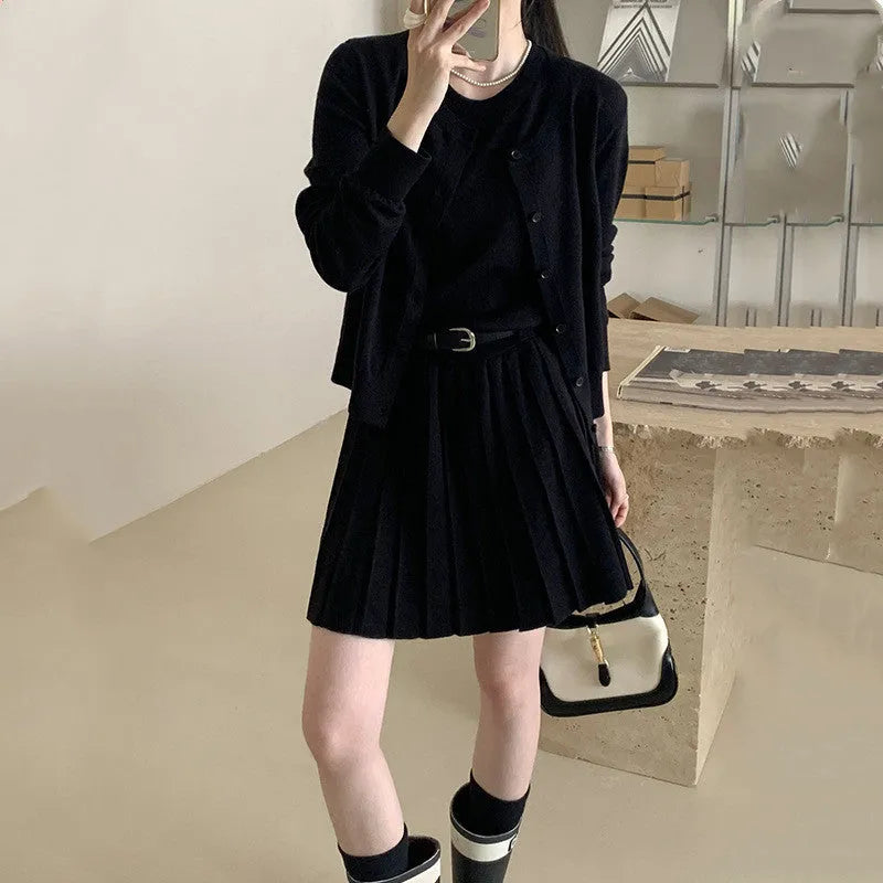 Women's black knitted polyester vest skirt and long sleeve cardigan two-piece set with a belt.