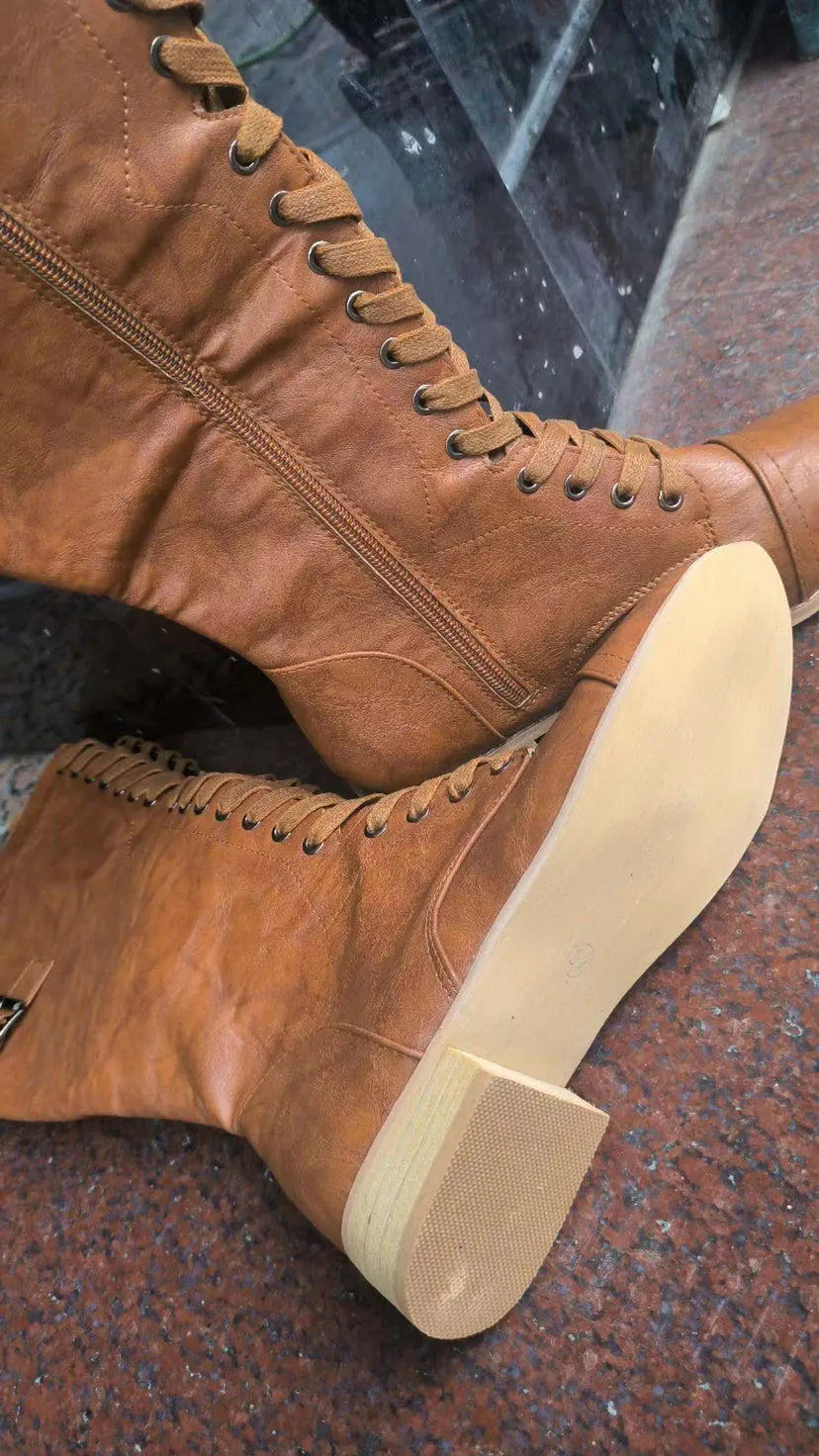 Women's black cross strap knight boots made from PU leather, showing the knee-high design and strap detail.