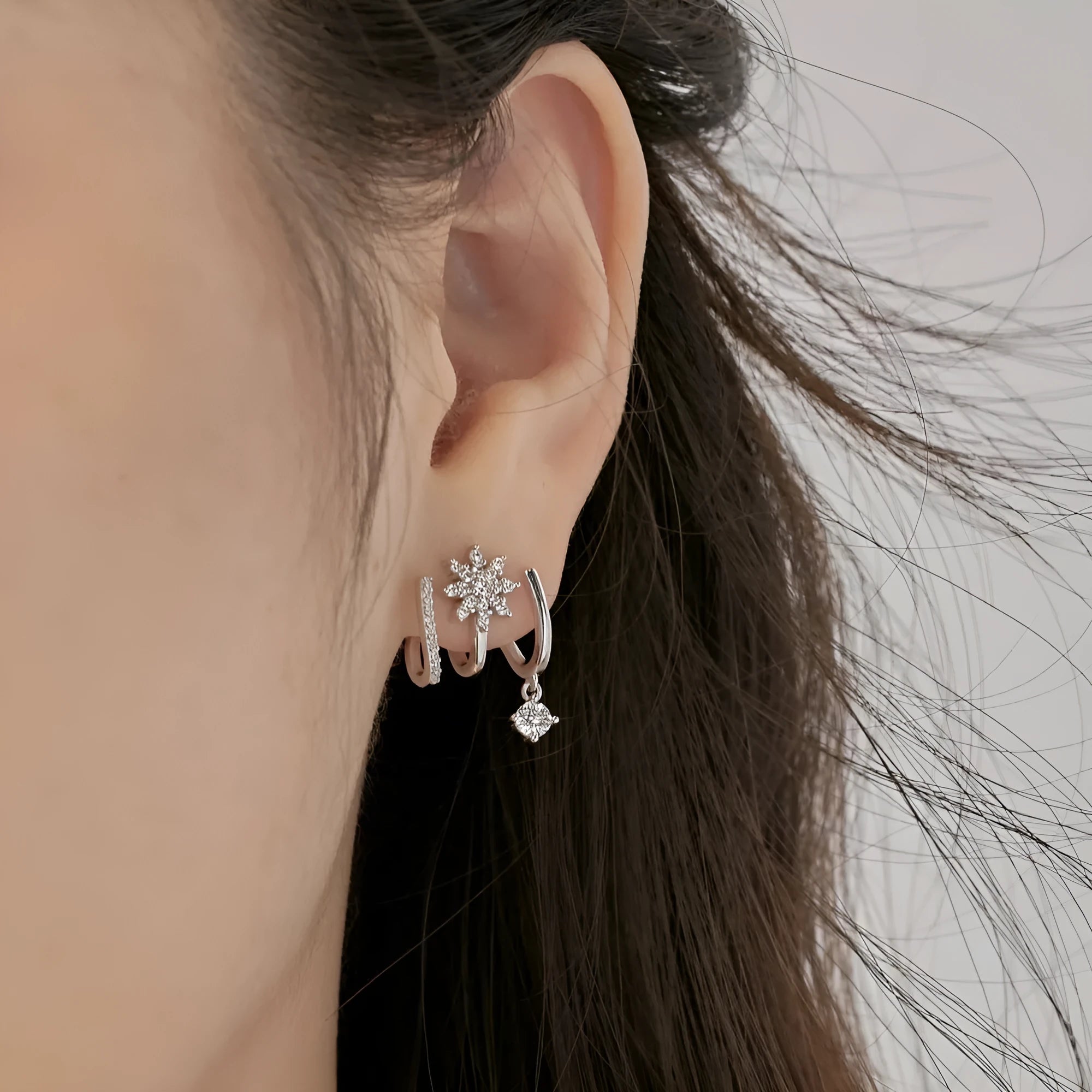 S925 sterling silver snowflake stud earrings in platinum finish with electroplated surface on white background