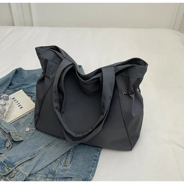 Soft Oxford cloth commuter tote bag in a street style, shown in a folded position.