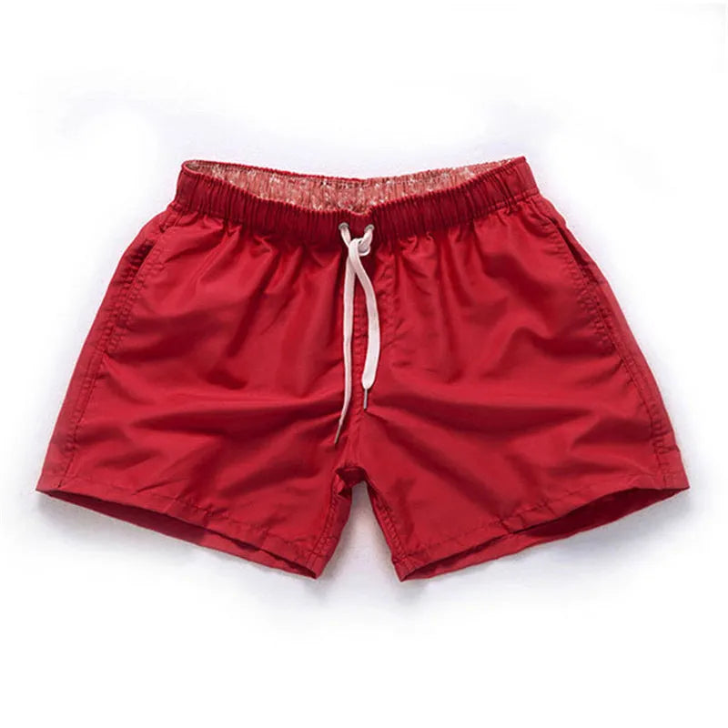 Men's straight-leg beach shorts in polyester fabric shown in a solid colour, laid flat.