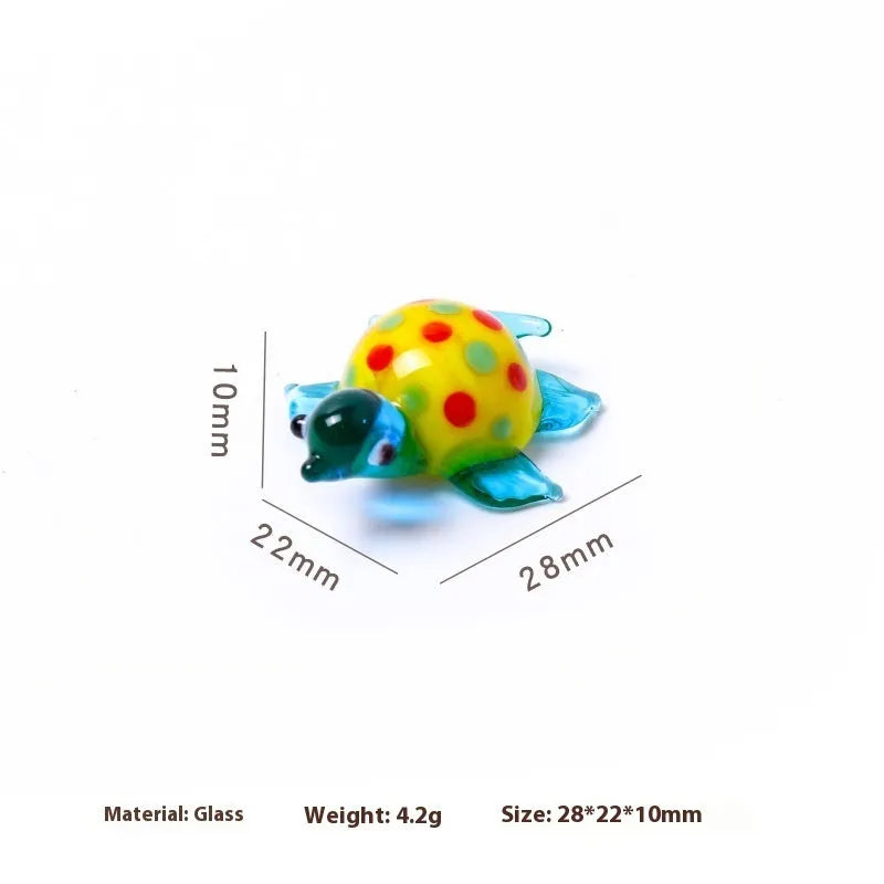 Geometric glass turtle ornament in a modern style with a coloured shell, displayed on a desktop.