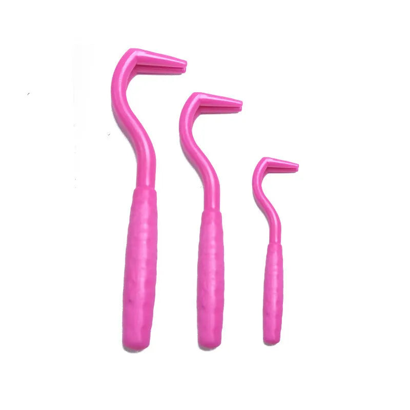 Set of three coloured tick removal hooks for dogs on a white background.