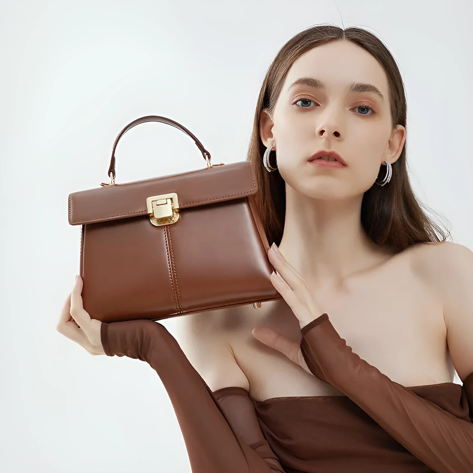 Women's black genuine leather shoulder bag with gold clasp closure showing interior compartments