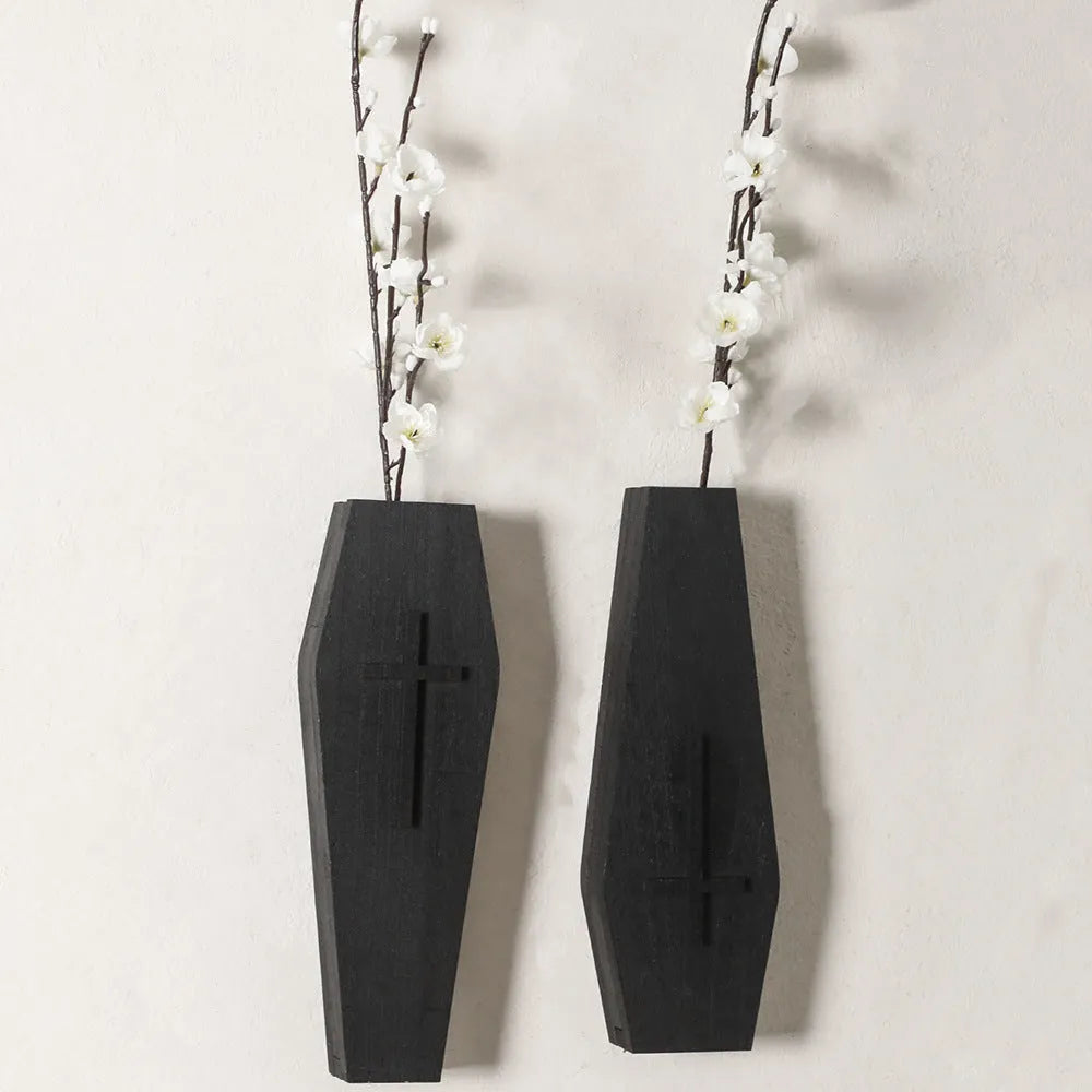 Black wooden cross-shaped wall shelf with a small ledge, measuring 27cm tall.