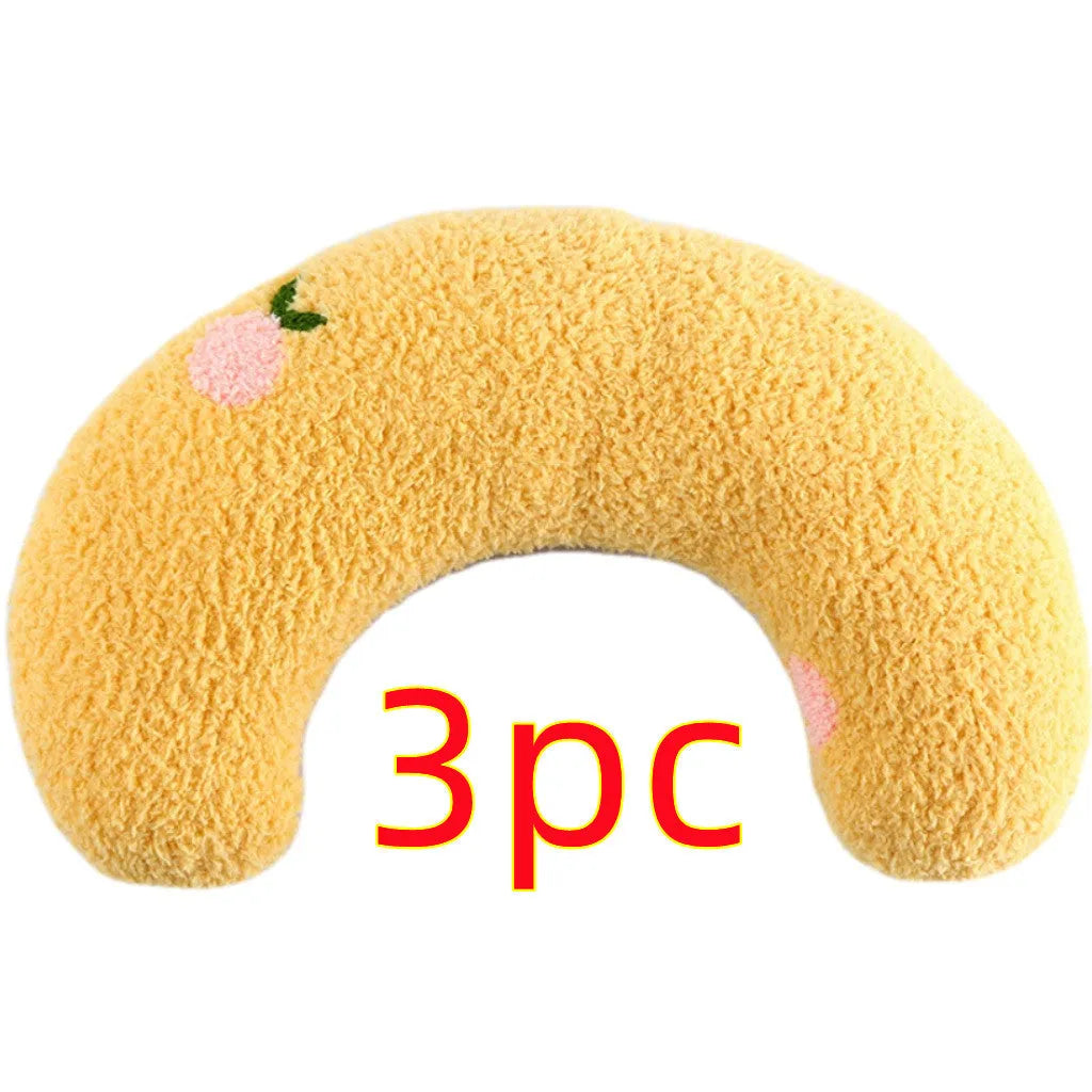 Small white U-shaped plush pet pillow for cats and small dogs on a neutral background.