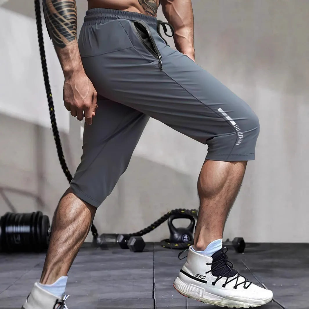 Man wearing grey cropped nylon sports pants with straight leg for summer beach activity
