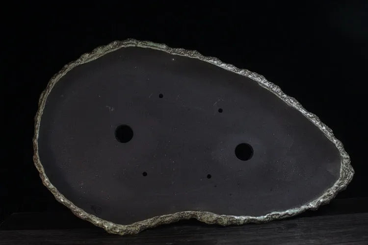Handmade purple clay flower pot showing unique shape and traditional ceramic texture