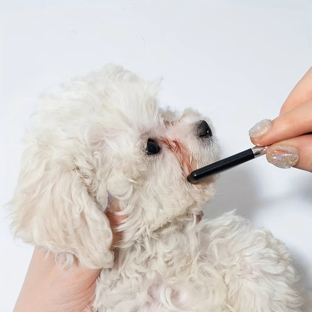 Black pet grooming brush with soft silicone bristles and comb attachment for tear stain removal on dogs and cats
