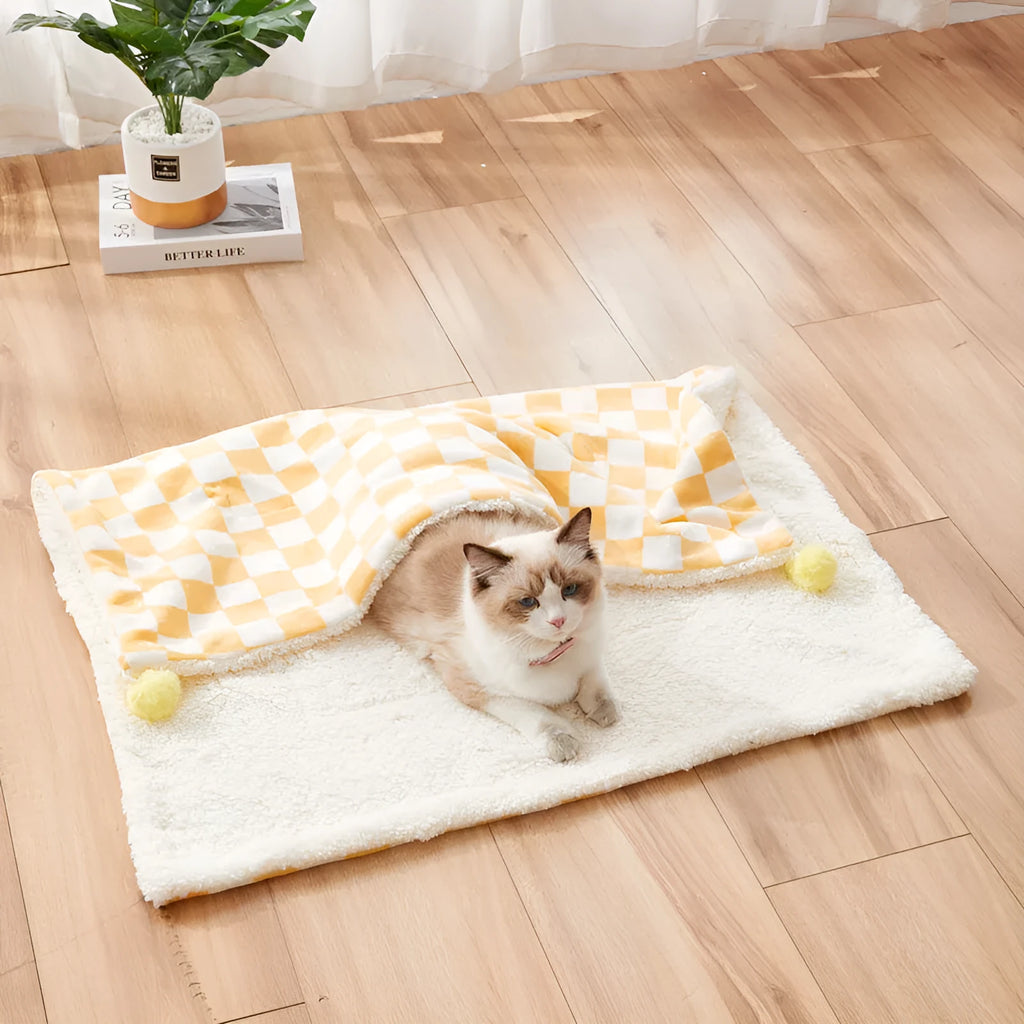 Plush pet blanket with plaid pattern and decorative fur ball in green colour