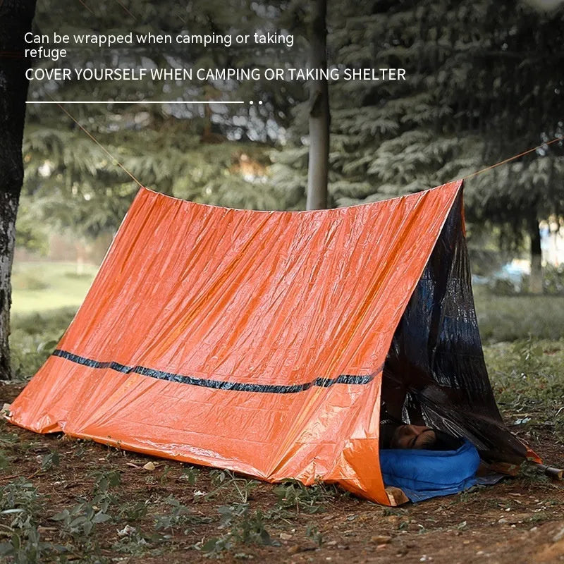 Orange portable disaster relief tent kit with sleeping bag and emergency blanket laid out.