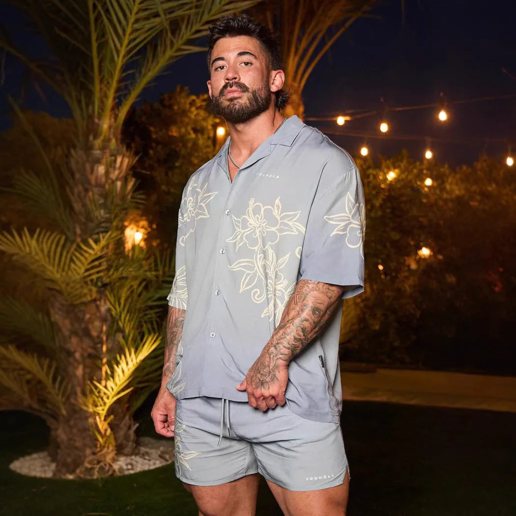 A man's loose-fitting, short-sleeve casual top with a floral print, shown in a light colour.