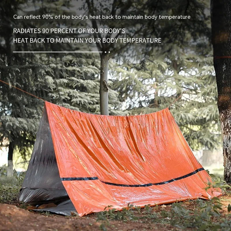 Orange portable disaster relief tent kit with sleeping bag and emergency blanket laid out.