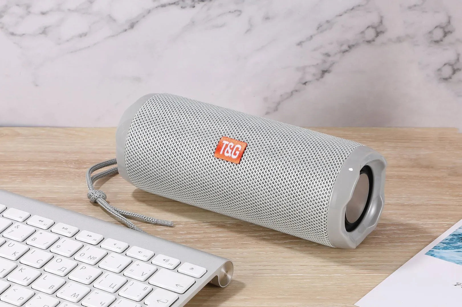 Fabric-covered portable Bluetooth speaker in multiple colours showing card holder slot.