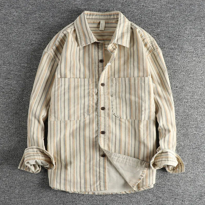 Man wearing a vintage-style striped overalls shirt in apricot colour with long sleeves and loose fit.