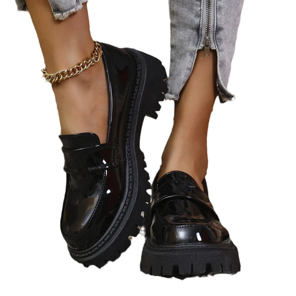 Women's black slip-on loafers with a chunky block heel and platform sole, shown from the side.
