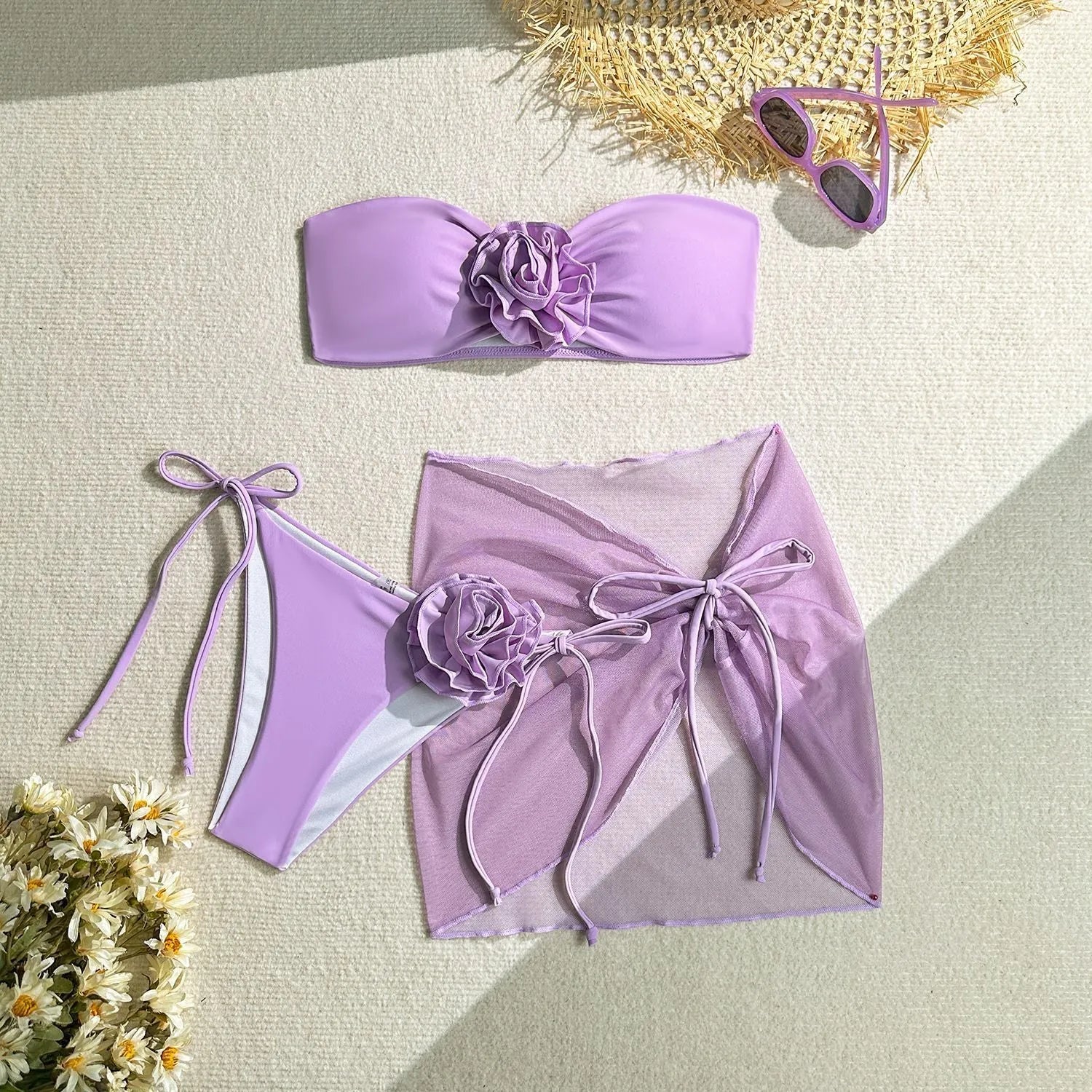 Women's pink tube top bikini with large 3D flower, matching bottoms, and skirt laid flat.
