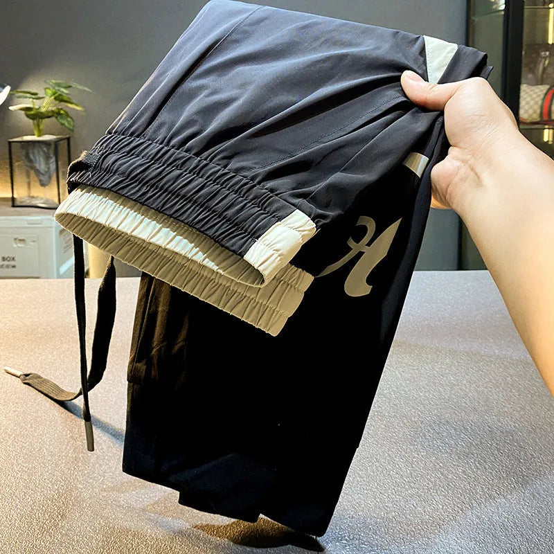 Men's solid black cotton cropped trousers with ankle banded style on hanger