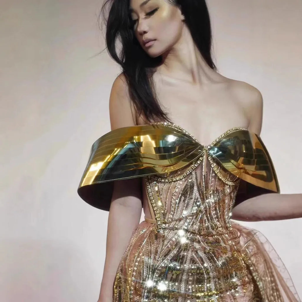 Gold strapless sequined evening dress with a high split tulle skirt.