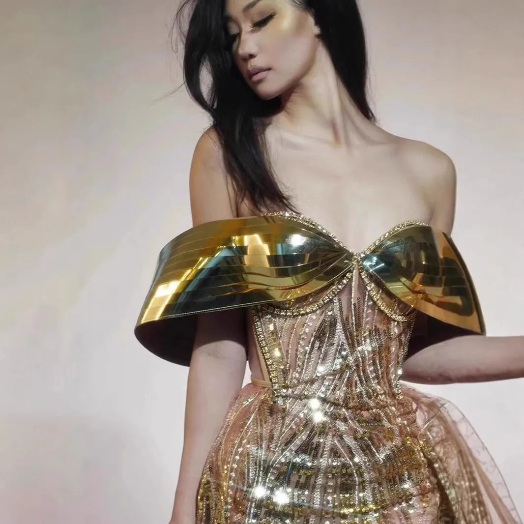 Gold strapless sequined evening dress with a high split tulle skirt.