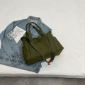 Large black polyester canvas shoulder tote bag showing outer sandwich pocket.
