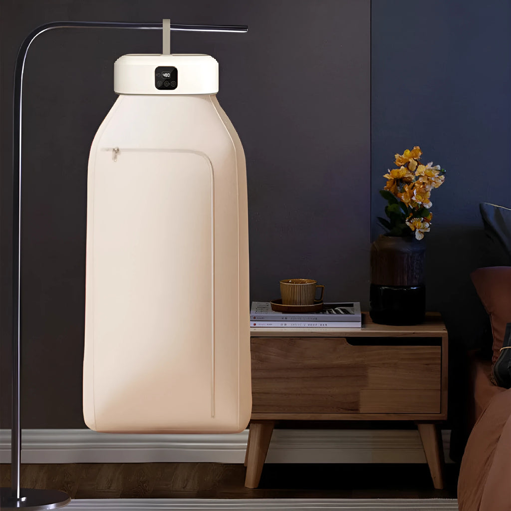 White cylindrical foldable laundry drier with remote control on flat surface