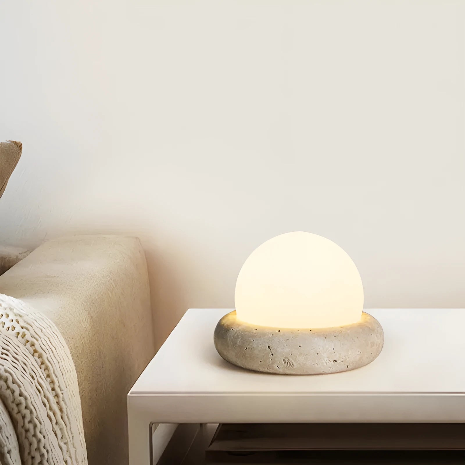 Cream-coloured modern bedside night lamp with remote control on wooden table