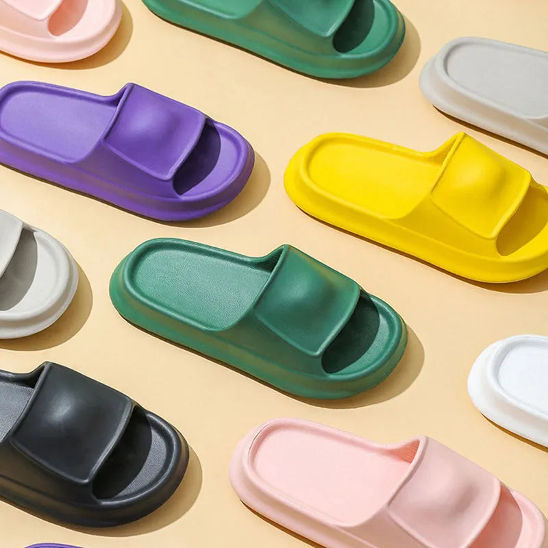 Pair of thick-soled white EVA foam flip-flop slippers on a bathroom floor, showing non-slip tread pattern.