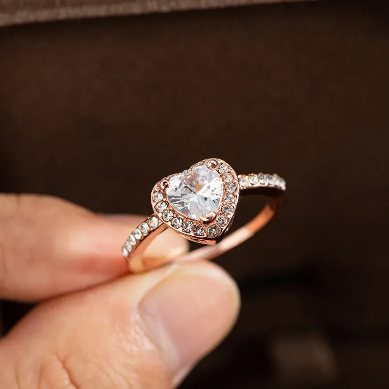 Heart-shaped women's ring with crystal decoration in rose gold or silvery finish on a size chart.