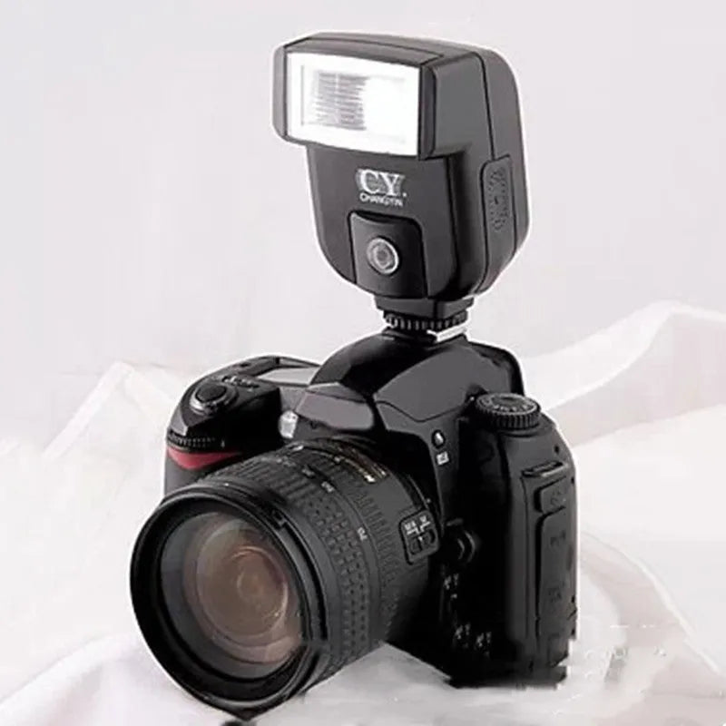 Silver top-mount SLR camera flash accessory with head tilted up, showing hot shoe mount and battery compartment.