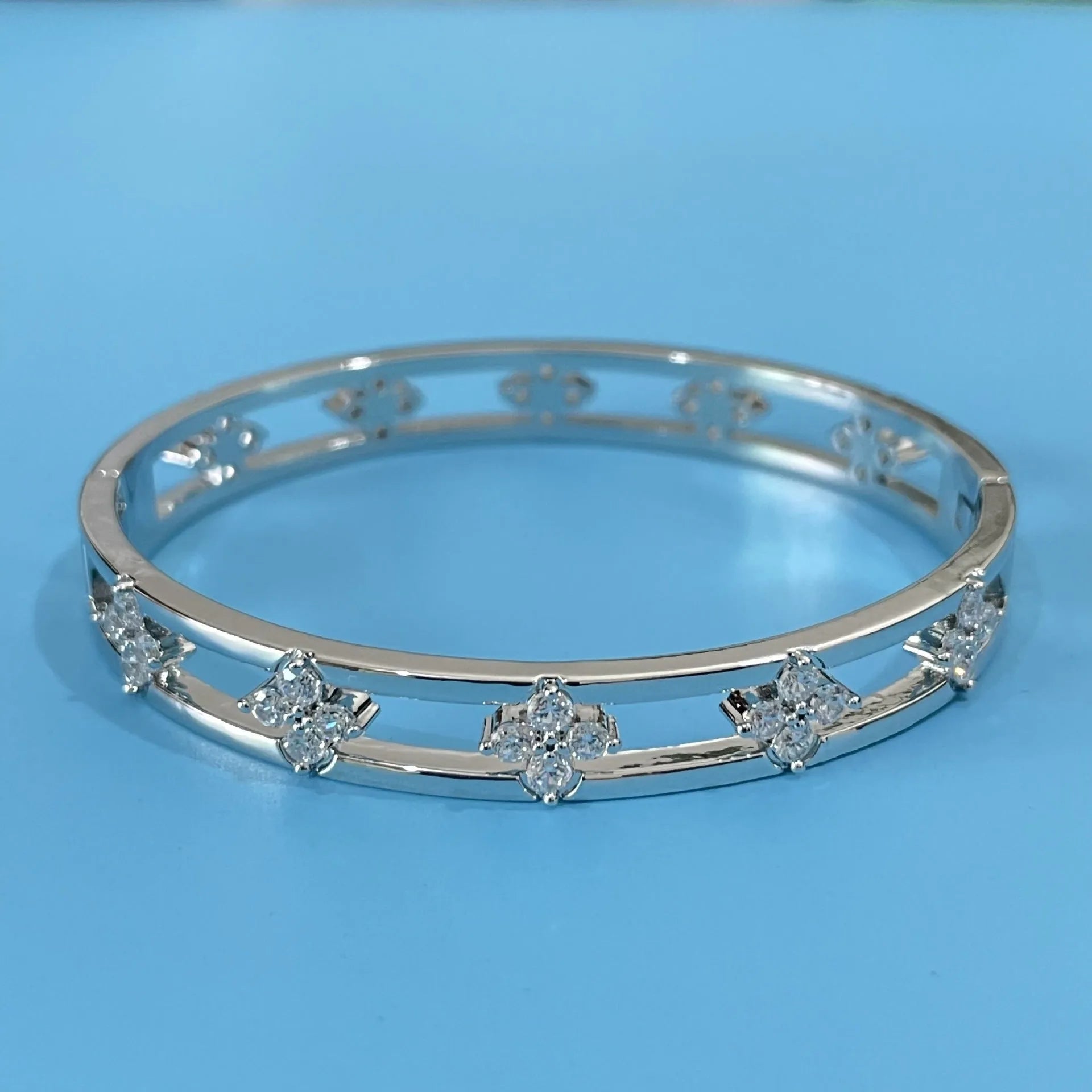 Women's hollow bracelet with four-leaf clover charm and zircon stones in gold or silver tone