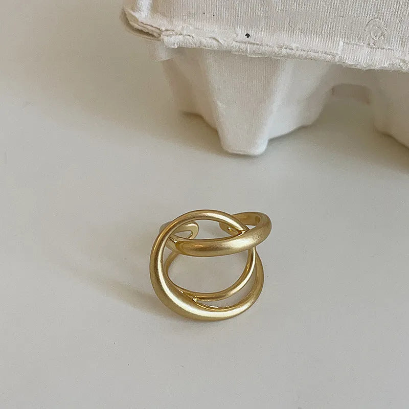 Geometric open ring with three-dimensional interlaced matte metal design in gold or silver electroplated finish