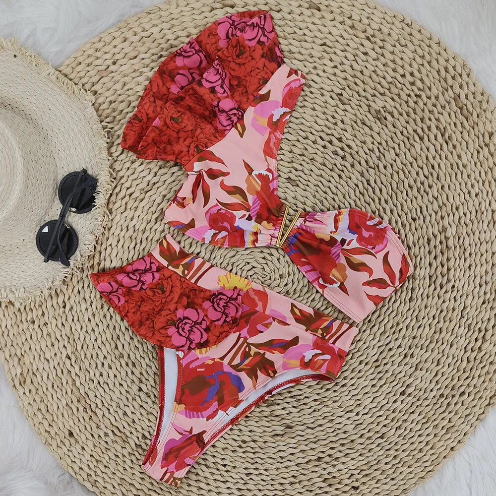 Women's pink floral print one-shoulder bikini with ruffle trim and high-waisted split briefs.