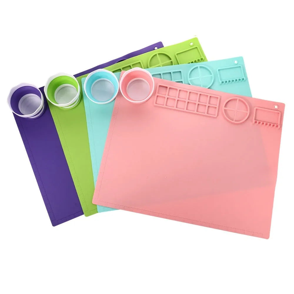 Light blue silicone painting mat with two round bowl compartments, measuring 50 by 40 cm.