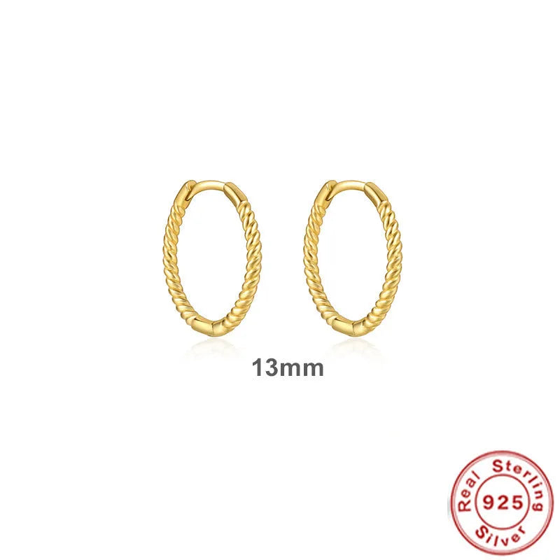 A pair of twisted sterling silver round earrings in a geometric design on a white background.