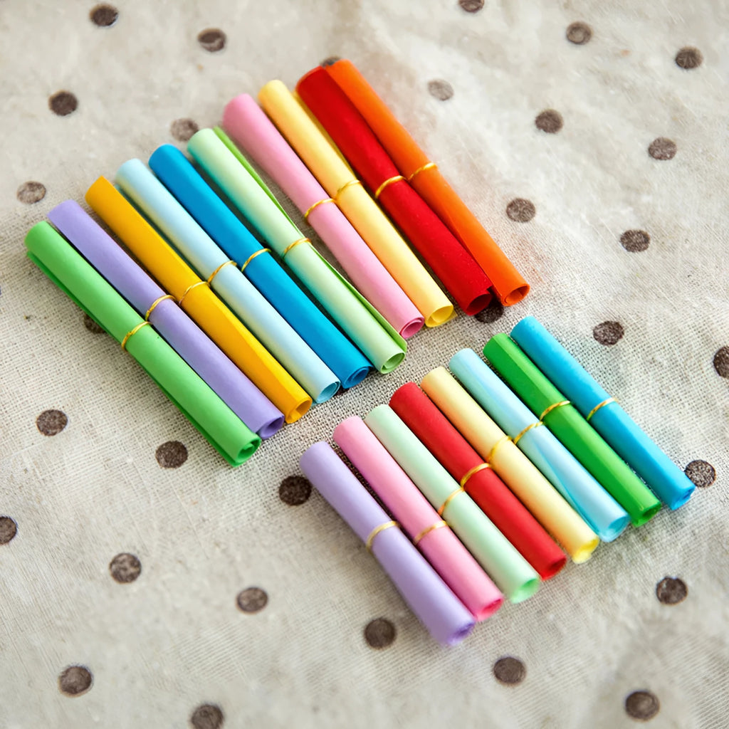 Assorted colourful paper scrolls with metal eyelets for messages and craft projects.