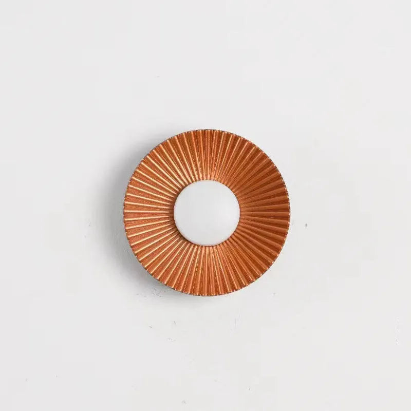 Round aluminium wall lamp mounted on a wall, showing a white and gold two-tone finish.