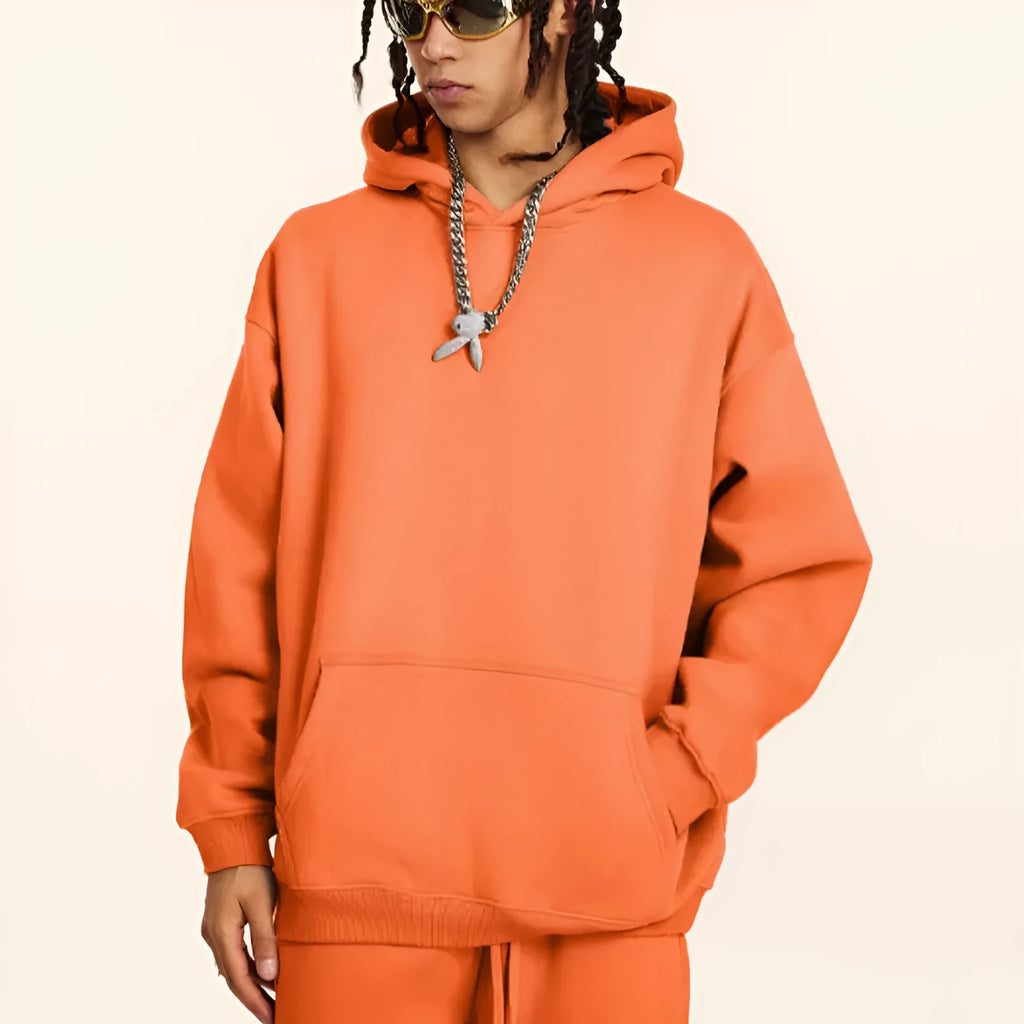 Man wearing a loose-fit grey cotton hooded sweater with drop-shoulder sleeves.